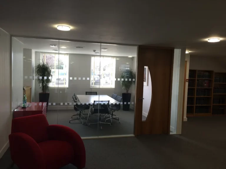 PDT Solicitors | Office space with glass partitions and wooden doors.
