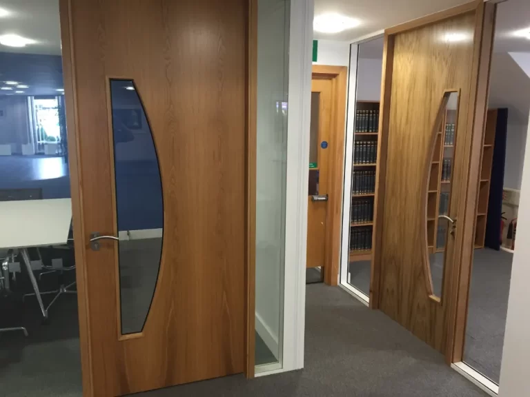 PDT Solicitors | Office space with glass partitions and wooden doors.
