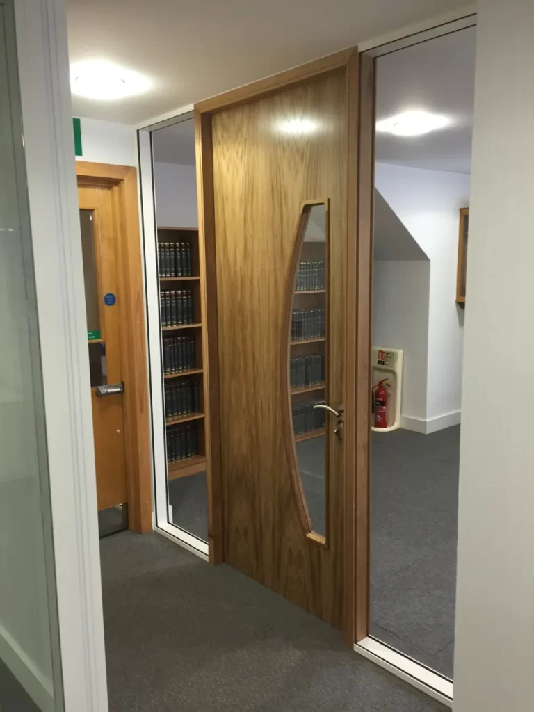 PDT Solicitors | Office space with glass partitions and wooden doors.